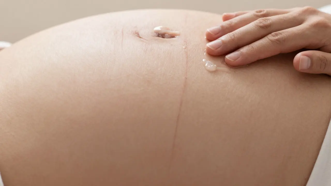 Detail kůže na těhotenském břiše s aplikací krému